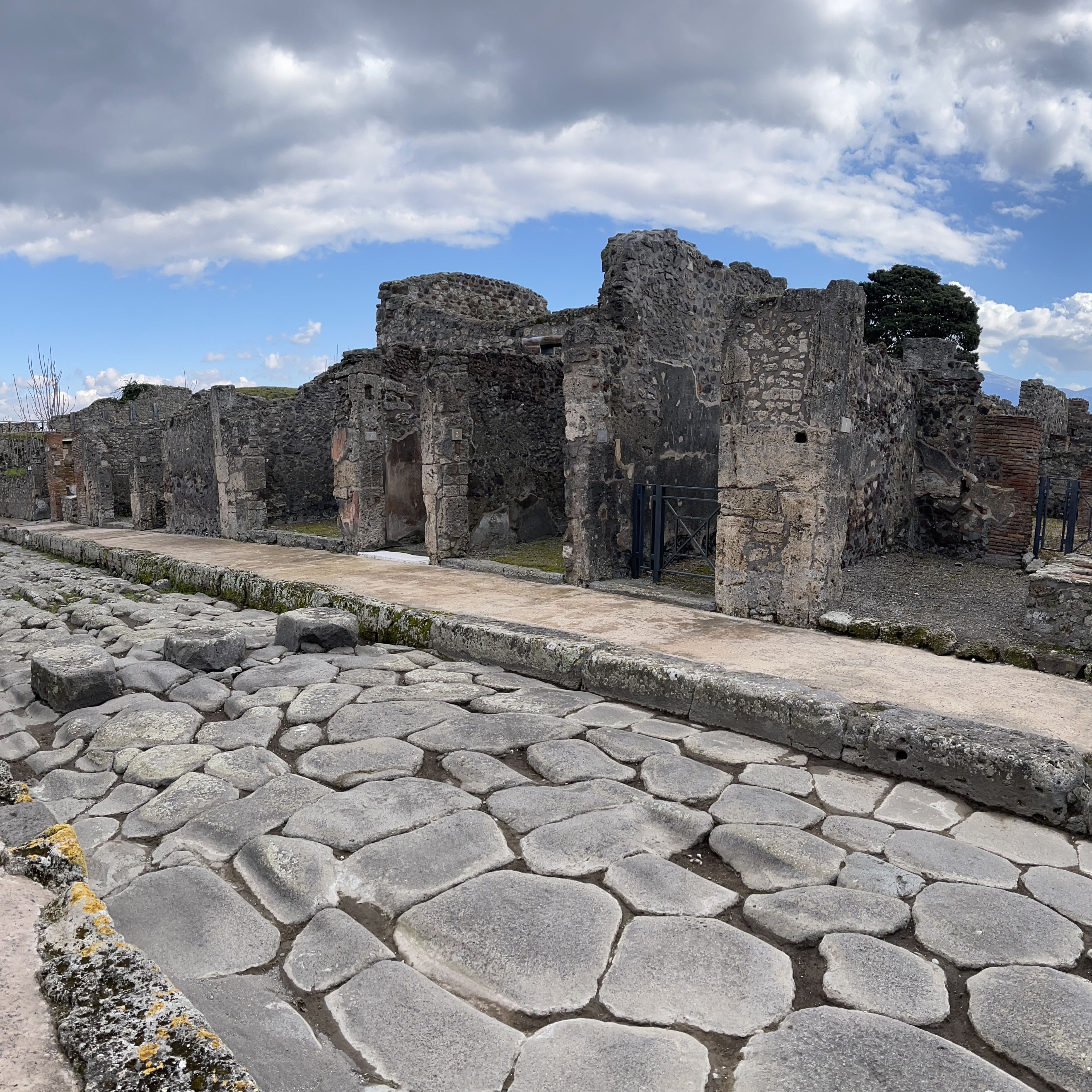 Straßen in Pompeji (2a−b) und Herculaneum (2c). Die polygonalen Steinplatten der Straßendecke fügten sich nahtlos aneinander. Über „Zebrastreifen“ konnten Fußgänger trockenen Fußes die Straßenseite wechseln (2b). Für die Karren wurden Joche im Überweg freigelassen.
