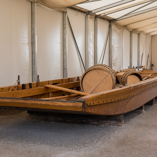 Nachbau eines hölzernen römischen Flachbodenschiffes, ausgestellt in einem modernen Zeltpavillon