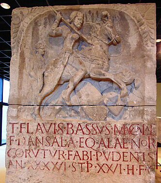 Foto eines Grabsteins mit Reliefdarstellung des Reitersoldaten Titus Flavius Bassus auf seinem Pferd im Kampf. Er verstarb im 26. Dienstjahr. Römisch-Germanisches Museum Köln.
