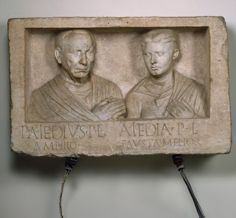 Das marmorne Grabrelief des Publius Aiedius Amphio und seiner Frau Aiedia Fausta Melior belegt den Erwerb des römischen Bürgerrechts der beiden Freigelassenen.