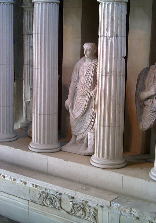 Foto des Grabmals des Legionsveteranen Lucius Poblicius. Die knapp lebensgroße Statue aus Kalkstein stellt den Verstorbenen als römischen Bürger mit der Toga dar. Römisch-Germanisches Museum Köln.
