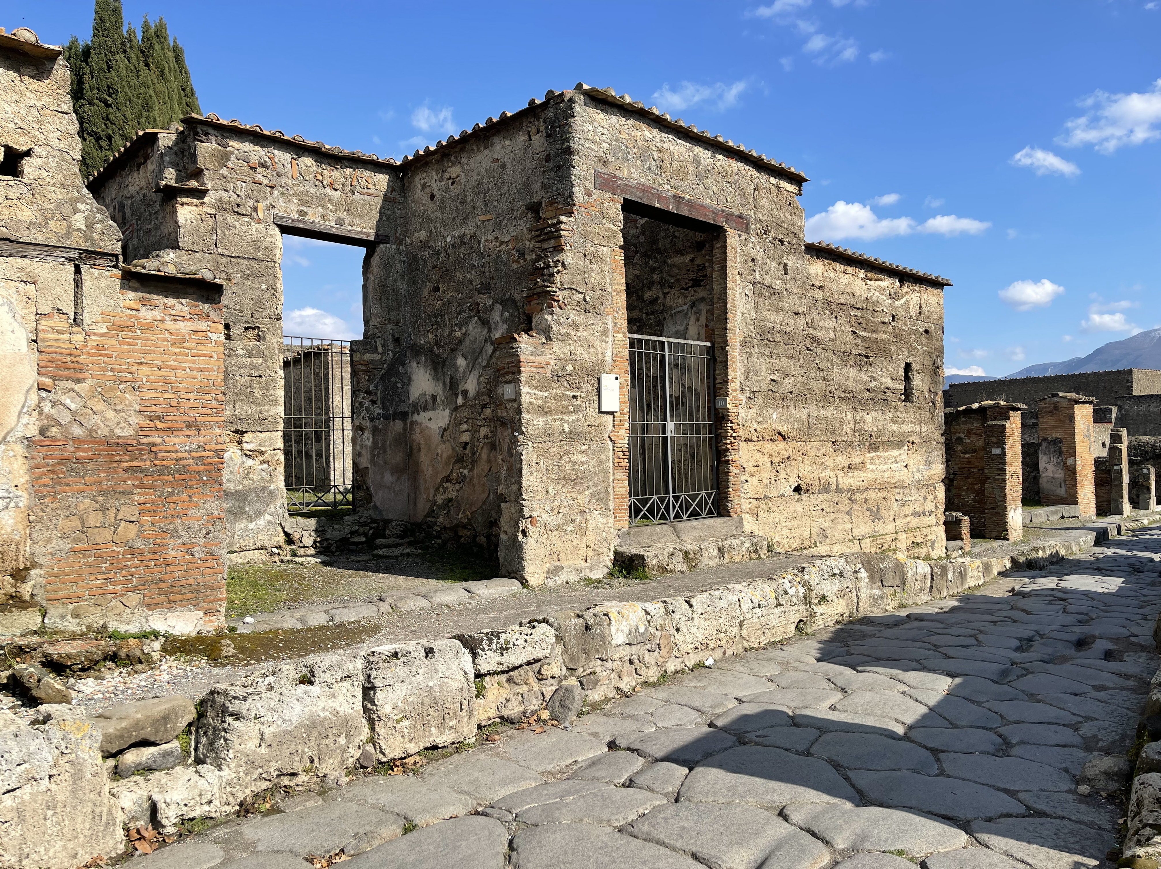 Aufnahme des sogenannten "Haus des Chirurgen" in Pompeji, einem Ziegelbau, vor blauem Himmel.