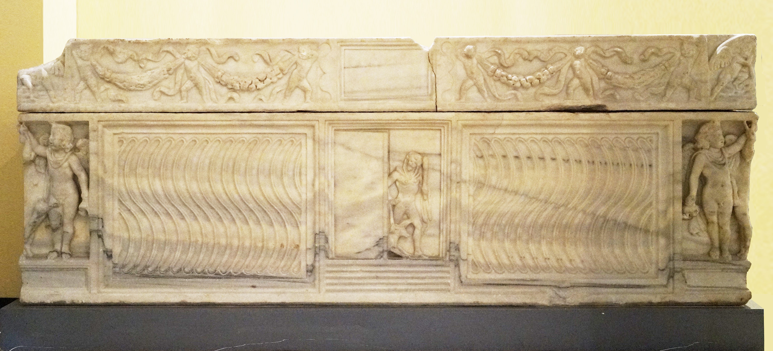Foto eines römischen Marmorsarkophages mit der Darstellung des Helden Heracles, der mit dem Hund Cerberos an der Leine aus dem Jenseits zurückkehrt. 2. Jh. n. Chr. Rom, Centrale Montemartini.